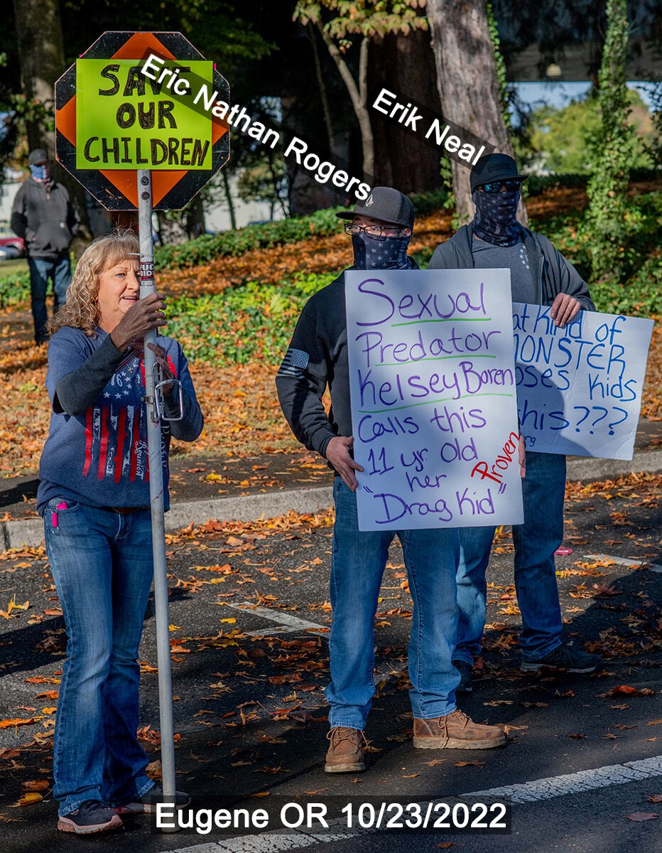 Eric Rogers stands with a large protest sign in Eugene. 