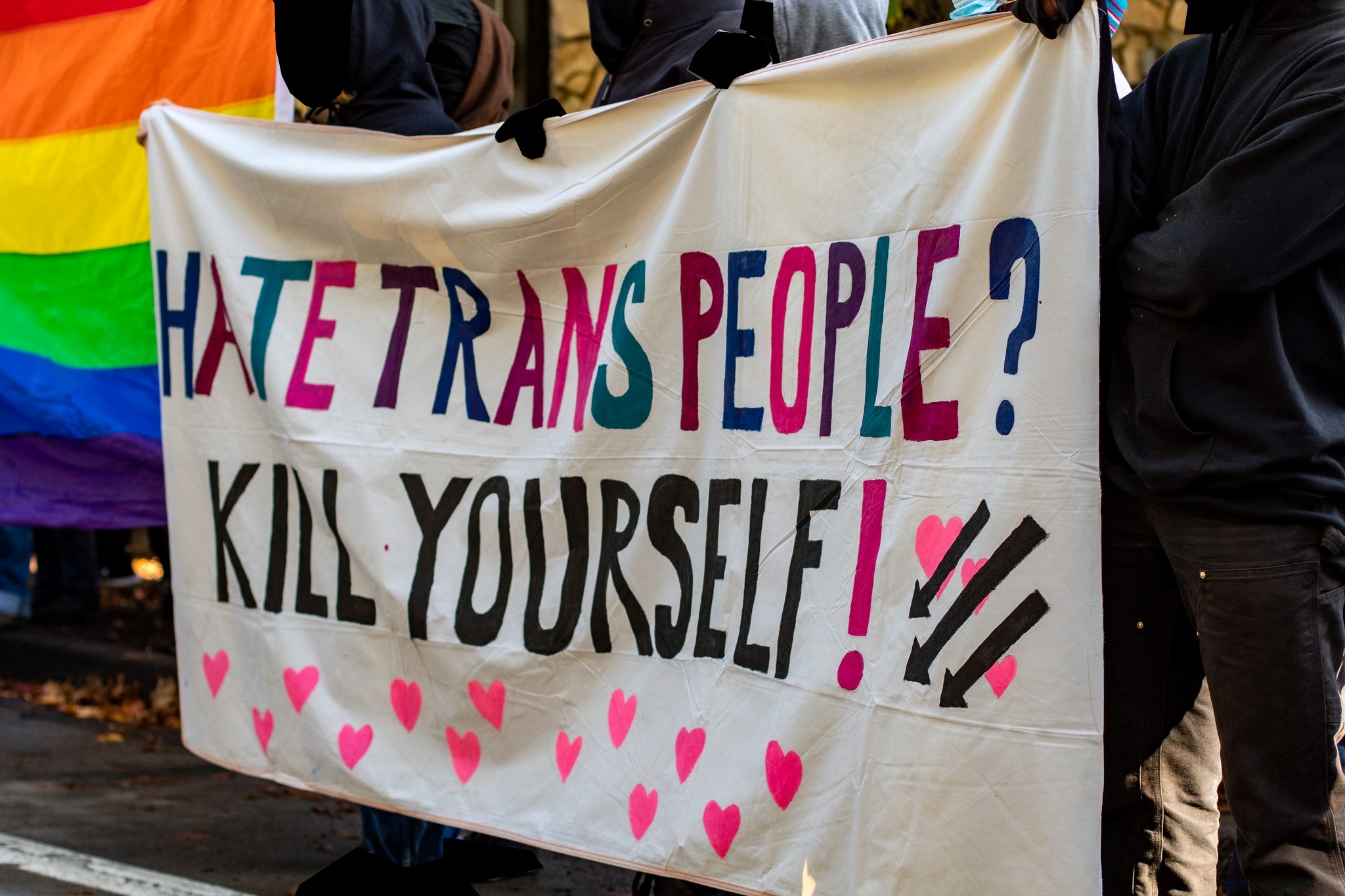 multi-colored banner reads "Hate Trans People? Kill Yourself!"
